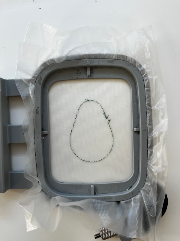 Avocado Kontur auf im Rahmen eingespanntes wasserlösliches Stickvlies gestickt